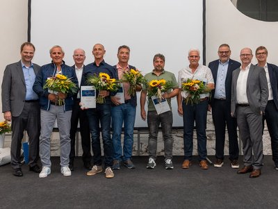 35 Jahre im Unternehmen (v.l.): Joachim Kraft, Michael Schwab, Peter Lehmann, Jürgen Schlessmann und Udo Kirchner (alle mit Blumen) mit der Geschäftsführung